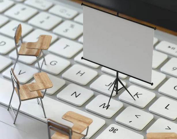 Desks on a keyboard looking at a projector
